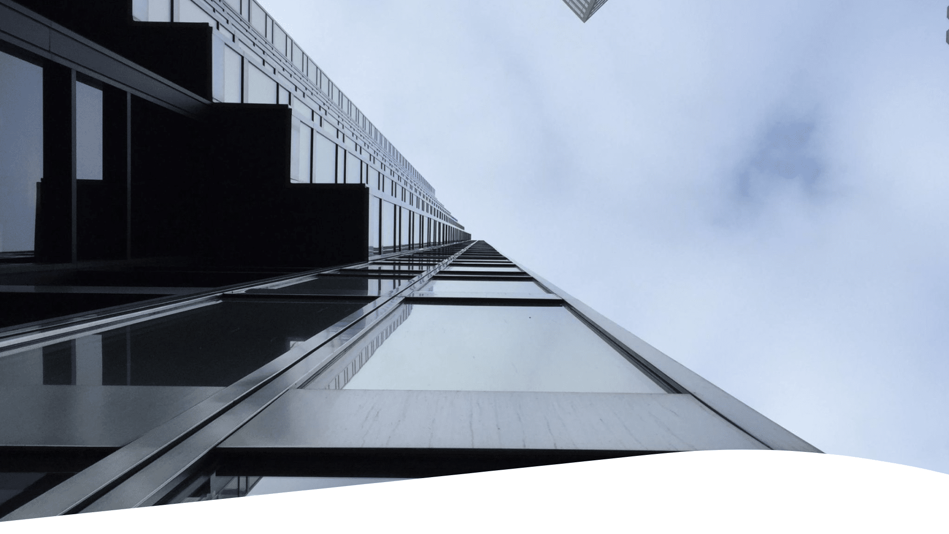 A low angle view of skyscrapers against a cloudy sky.
