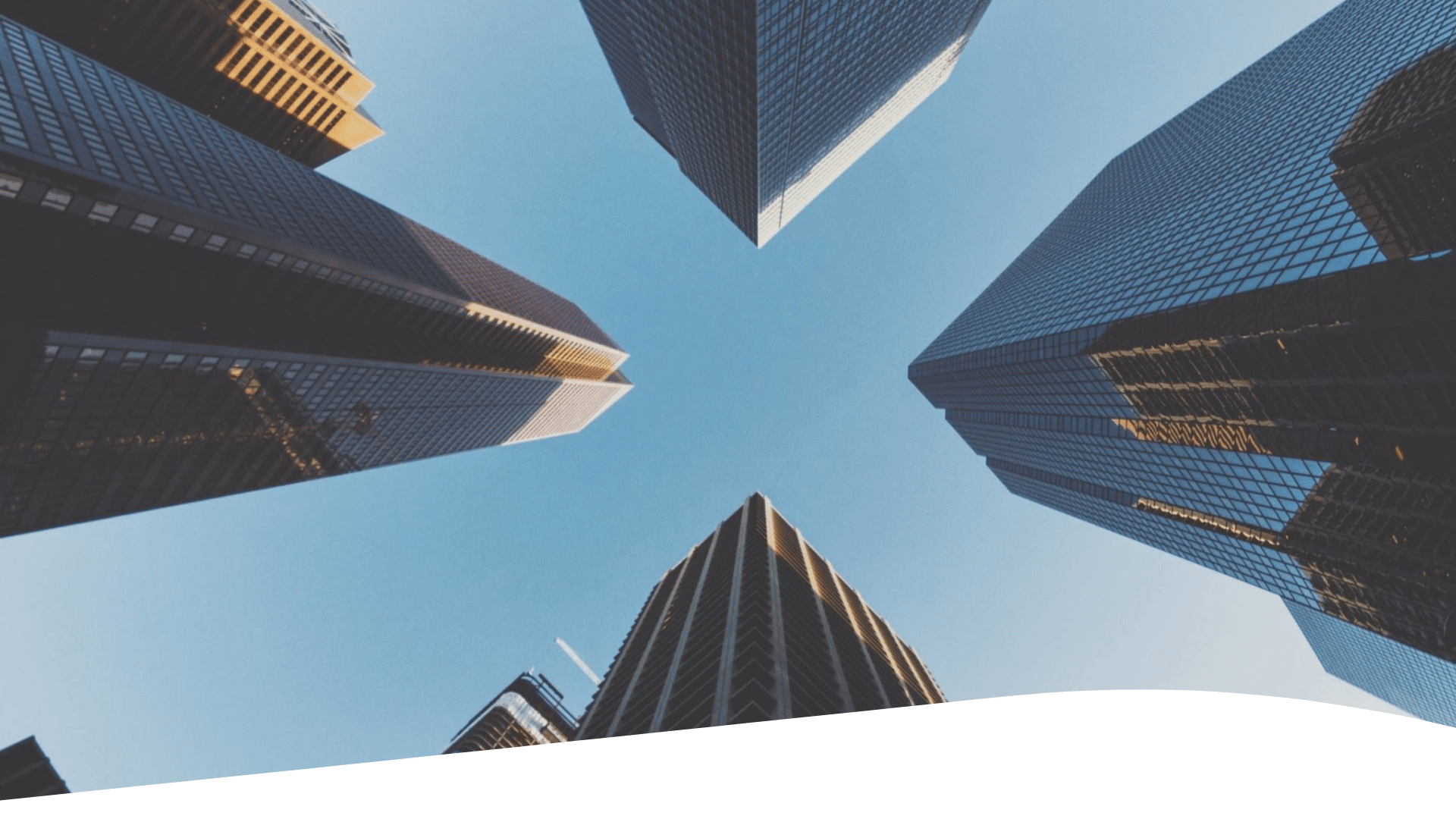 A group of towers against a blue sky as seen from below.