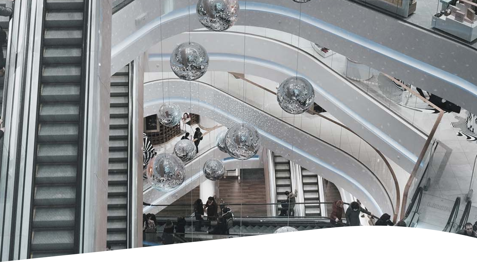 A group of people going up the escalator at an indoor mall.